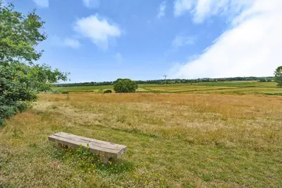 a wooden bench sitting in the middle of a field at 3 Bed in Blythburgh oc-h32647 in Blyford