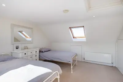 a white room with two beds and a mirror at 3 Bed in Aldeburgh oc-f32700 in Aldeburgh