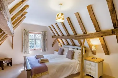 a bedroom with a large bed with wooden beams at 4 Bed in St. Nicholas South Elmham oc-o32397 in Saint Margaret