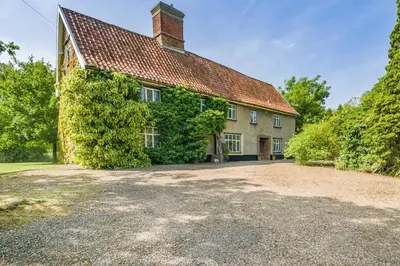 an ivy covered house with a large driveway at 4 Bed in St. Nicholas South Elmham oc-o32397 in Saint Margaret