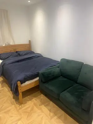 a bed and a green couch in a room at High street in Toft
