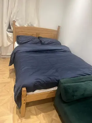 a bed with a blue comforter in a bedroom at High street in Toft