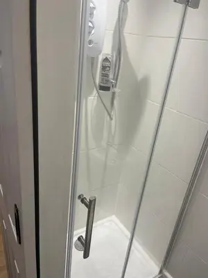 a shower stall with a phone in a bathroom at High street in Toft