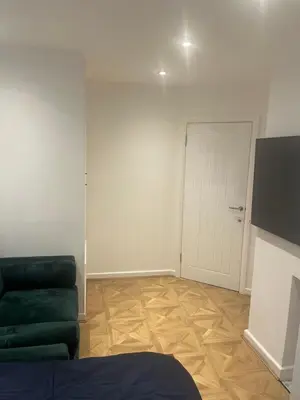 a living room with a green couch and a door at High street in Toft