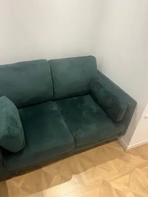 a green couch sitting in a living room at High street in Toft