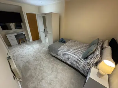 a bedroom with a bed and a desk with a lamp at Apartment in Suffolk in Ipswich
