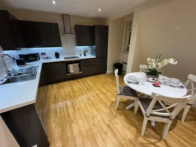 a kitchen and dining room with a white table and chairs at Apartment in Suffolk in Ipswich