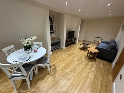 a living room with a white table and a couch at Apartment in Suffolk in Ipswich