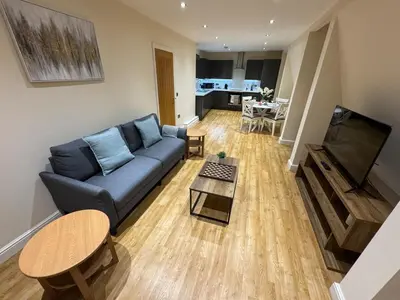 a living room with a blue couch and a table at Apartment in Suffolk in Ipswich