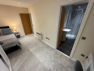 a bedroom with a bed and a bathroom with a shower at Apartment in Suffolk in Ipswich