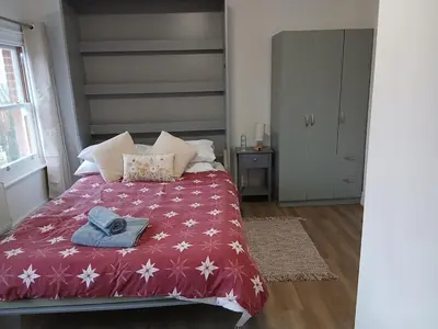 a bedroom with a bed with a red blanket at Private En-Suite Room by Christchurch Park - room 6 in Ipswich