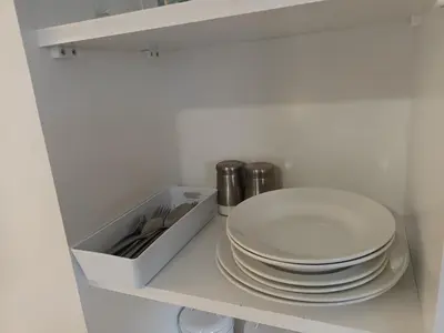 a pile of plates sitting on a shelf next to a stack of dishes at Private En-Suite Room by Christchurch Park - room 6 in Ipswich