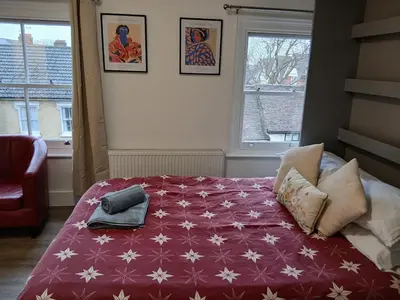 a bedroom with a bed with a red blanket with white stars at Private En-Suite Room by Christchurch Park - room 6 in Ipswich