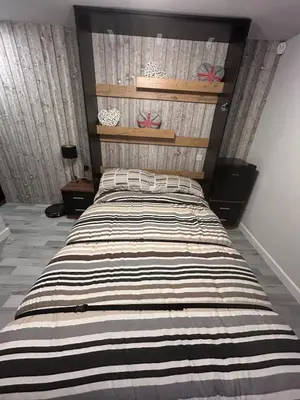 a bedroom with a large bed with a striped comforter at Somewhere Nice & Cozy in Little Clacton
