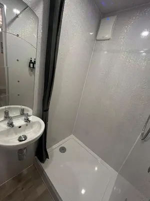 a white bathroom with a sink and a shower at Somewhere Nice & Cozy in Little Clacton