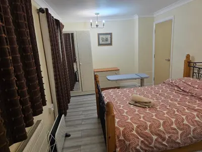 a bedroom with a bed and a table and a window at Colchester chill x1 in Hythe