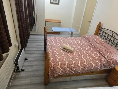 a bedroom with a bed with a blanket and a table at Colchester chill x1 in Hythe