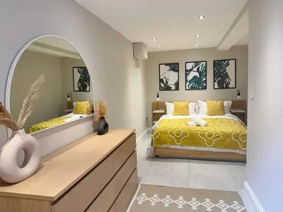 a bedroom with a bed and a large mirror at Central Bury Apartment with Private Entrance in Bury Saint Edmunds