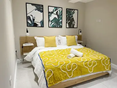 a bedroom with a large bed with a yellow blanket at Central Bury Apartment with Private Entrance in Bury Saint Edmunds