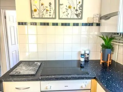 a kitchen with a black counter top in a room at Lime Tree in blue House in Cambridge