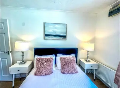 a bedroom with a bed with two lamps on it at Lime Tree in blue House in Cambridge