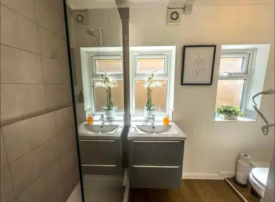 a bathroom with two sinks and two windows at Lime Tree in blue House in Cambridge