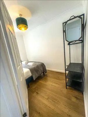 a bedroom with a bed and a tv on the wall at Lime Tree in blue House in Cambridge