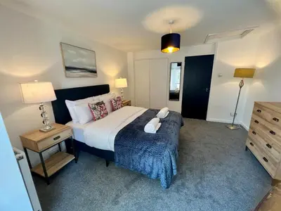 a bedroom with a large bed and a night stand at Lime Tree in blue House in Cambridge