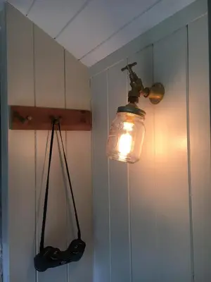a light hanging from a wall with a light fixture at The Scrumpy Shepherd, Brandeston in Blundeston