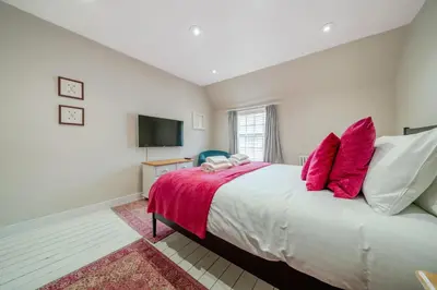 a bedroom with a large bed with red pillows at 136 Southgate St, Bury St Edmunds in Bury Saint Edmunds