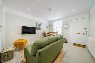 a living room with a green couch and a television at 136 Southgate St, Bury St Edmunds in Bury Saint Edmunds
