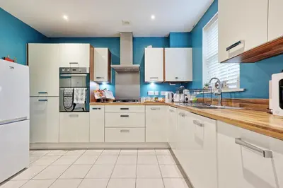 a kitchen with white cabinets and blue walls at Spacious 4BR Townhouse, Sleeps 9, Fast WIFI, FREE PARKING, Contractor friendly in Colchester