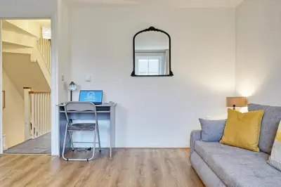 a living room with a desk and a couch at Spacious 4BR Townhouse, Sleeps 9, Fast WIFI, FREE PARKING, Contractor friendly in Colchester