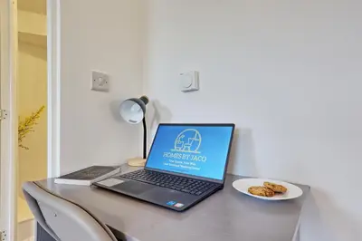 a laptop computer sitting on a table with a plate of food at Spacious 4BR Townhouse, Sleeps 9, Fast WIFI, FREE PARKING, Contractor friendly in Colchester