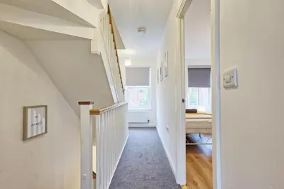 a hallway with white walls and a white stair case at Spacious 4BR Townhouse, Sleeps 9, Fast WIFI, FREE PARKING, Contractor friendly in Colchester