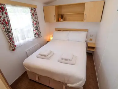 a small bedroom with a bed with two towels on it at 21 Poplar Avenue in Felixstowe