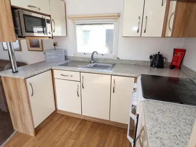 a kitchen with white cabinets and a sink at 21 Poplar Avenue in Felixstowe