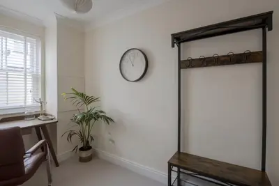 a room with a mirror and a clock on the wall at Amazing Abodes in Chelmsford