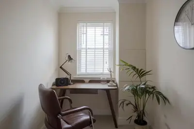 an office with a desk and a chair and a window at Amazing Abodes in Chelmsford