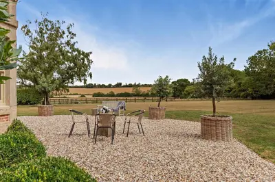 a table and chairs sitting on a gravel patio at 6 Bed in Cowlinge oc-b32762 in Cowlinge