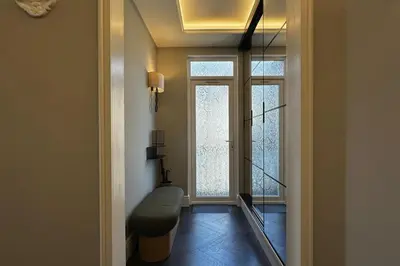 a hallway with a chair and a large window at Canewdon Rd Luxury Accommodation in Westcliff On Sea