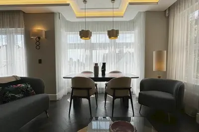 a living room with a dining room table and chairs at Canewdon Rd Luxury Accommodation in Westcliff On Sea