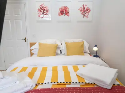 a bedroom with a bed with yellow and white pillows at Old Felixstowe, Bath Road in Felixstowe