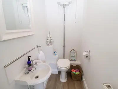 a white bathroom with a toilet and a sink at Old Felixstowe, Bath Road in Felixstowe