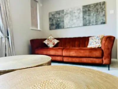 a brown leather couch in a living room with two tables at Luxury Homely Stay Near City Centre With Parking in Colchester