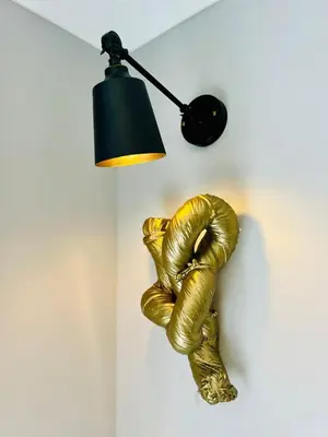 a golden hand on a wall under a lamp at Luxury Homely Stay Near City Centre With Parking in Colchester