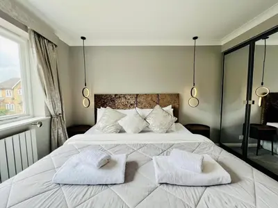 a bedroom with a large white bed with two towels on it at Luxury Homely Stay Near City Centre With Parking in Colchester