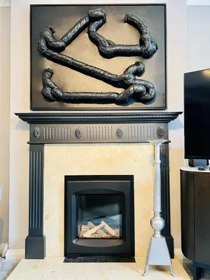 a fireplace with a statue of two people over it at Luxury Homely Stay Near City Centre With Parking in Colchester