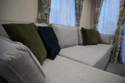 a white couch with green pillows in a living room at Neptune in Parkeston