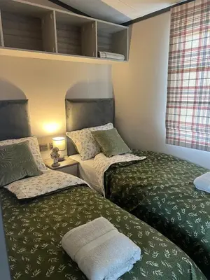 a bedroom with two beds with green sheets at Neptune in Parkeston